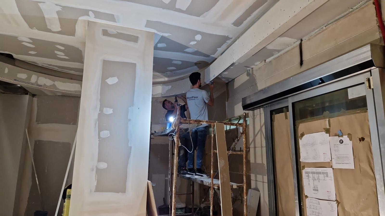 Equipa LTR num andaime a montar tetos curvos em pladur durante a obra